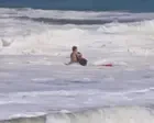 Teen lifeguard struggles to save boy from massive waves in California - video