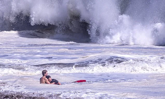 Brave lifeguard breaks silence after saving 10-year-old boy from monster surf after grandfather revealed young hero had made FIVE rescues on same day