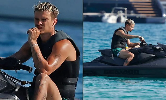 Romeo Beckham, 23, channels dad David's noughties style with blond locks and displays his muscles on jet ski ride during family Ibiza trip
