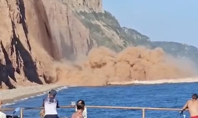 Moment 'hundreds of tonnes' of rock crash down onto beach metres away from sunbathers