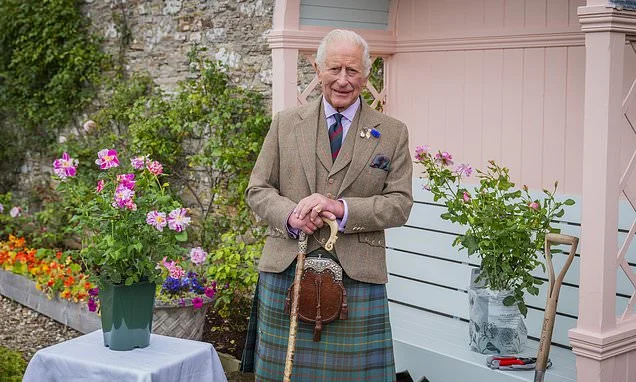 Beaming King Charles poses in a tartan kilt as he plants rose named in his honour at Queen Mother's former home before starting his annual Scottish summer break