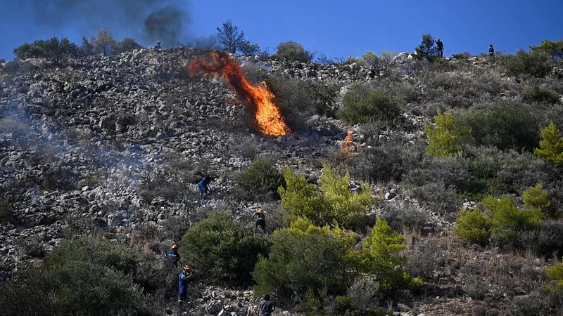 Fire crews battle blazes in Belgium and Greece as two die on island near Athens