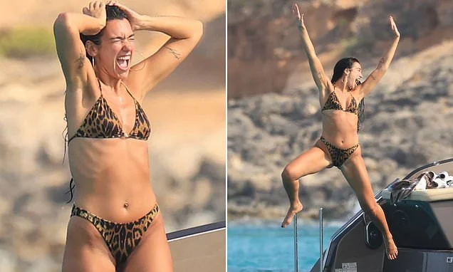 Bikini-clad Dua Lipa turns her family holiday into her own photoshoot as she poses up a storm in leopard print bikini and jumps off a boat in Formentera